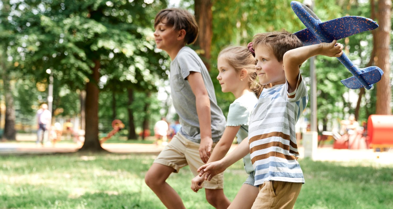 Group of kids playing together with airplane toy